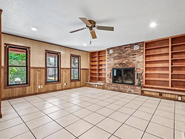 unfurnished living room featuring ceiling fan, built in features, light tile patterned floors, and a brick fireplace