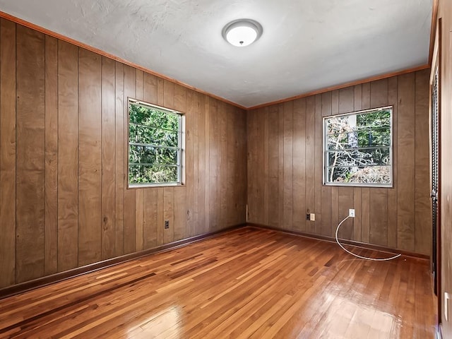 unfurnished room featuring wood walls and light hardwood / wood-style floors