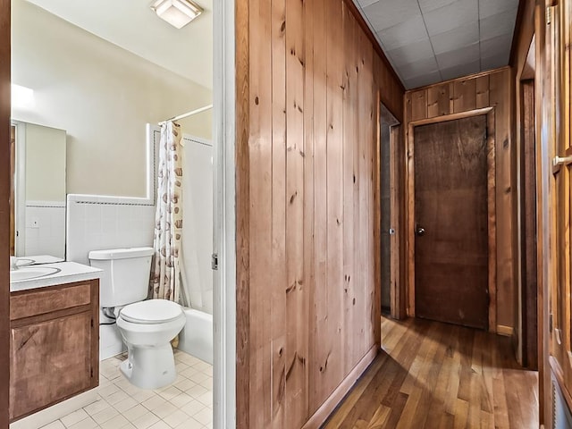 full bathroom with vanity, toilet, tile walls, and shower / bath combo with shower curtain