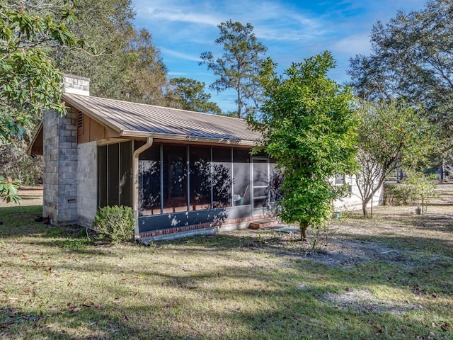 back of house with a lawn and a sunroom