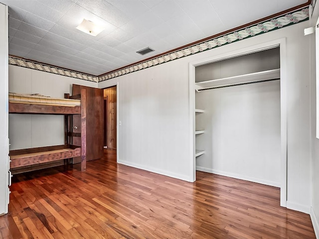 unfurnished bedroom featuring a closet and wood-type flooring