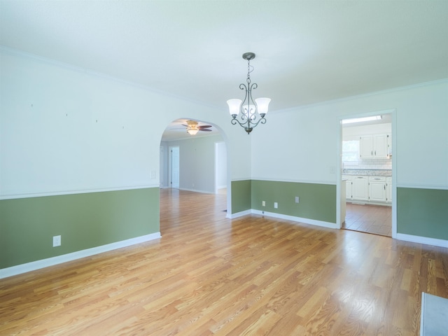 405 NW Whispering Pines Loop, Madison, FL 32340 - empty room featuring a chandelier, arched walkways, crown molding, light wood-style flooring, and ceiling fan