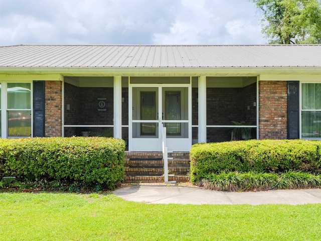 405 NW Whispering Pines Loop, Madison, FL 32340 - entrance to property with brick siding, a yard, and a metal roof