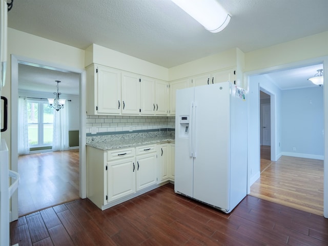 405 NW Whispering Pines Loop, Madison, FL 32340 - kitchen with white refrigerator with ice dispenser, a chandelier, dark wood-style floors, and tasteful backsplash