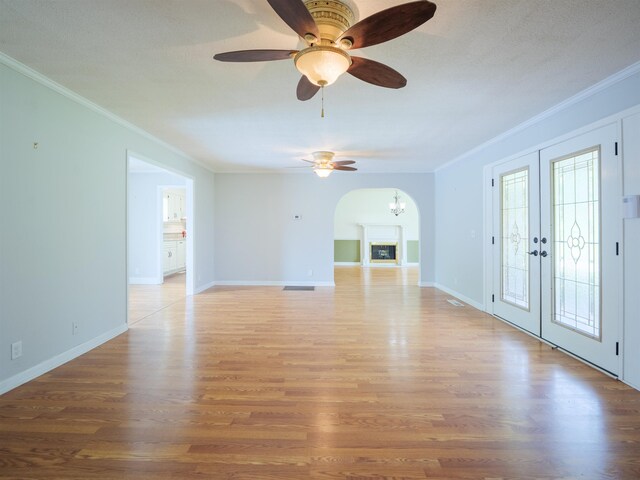 405 NW Whispering Pines Loop, Madison, FL 32340 - unfurnished living room featuring crown molding, ceiling fan, light wood finished floors, french doors, and arched walkways