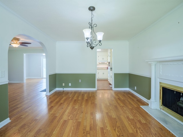 405 NW Whispering Pines Loop, Madison, FL 32340 - unfurnished dining area with a chandelier, crown molding, arched walkways, a fireplace with flush hearth, and light wood-style flooring