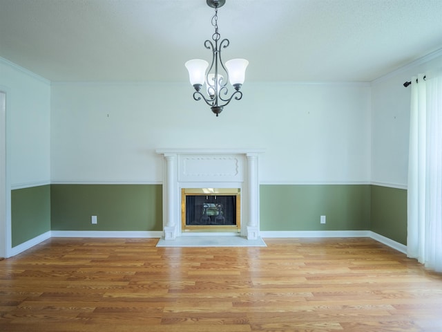 405 NW Whispering Pines Loop, Madison, FL 32340 - unfurnished living room with light wood-type flooring, a chandelier, a fireplace with flush hearth, and crown molding