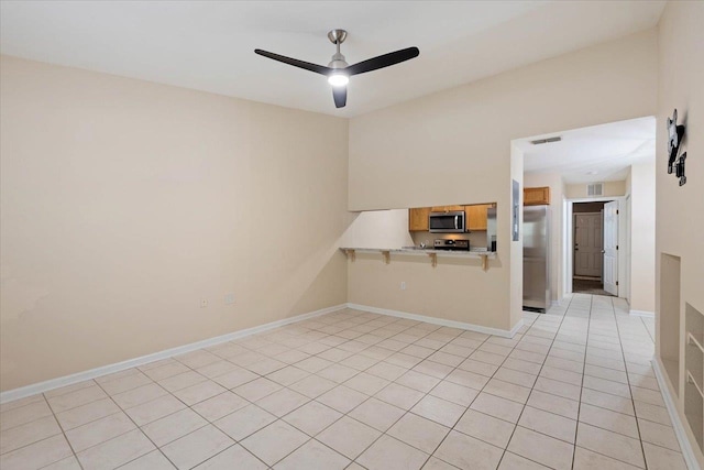 spare room featuring ceiling fan and light tile patterned floors