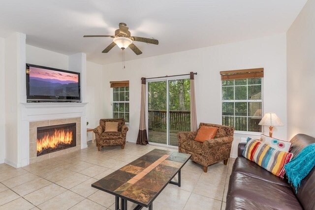 tiled living room featuring a tiled fireplace and ceiling fan