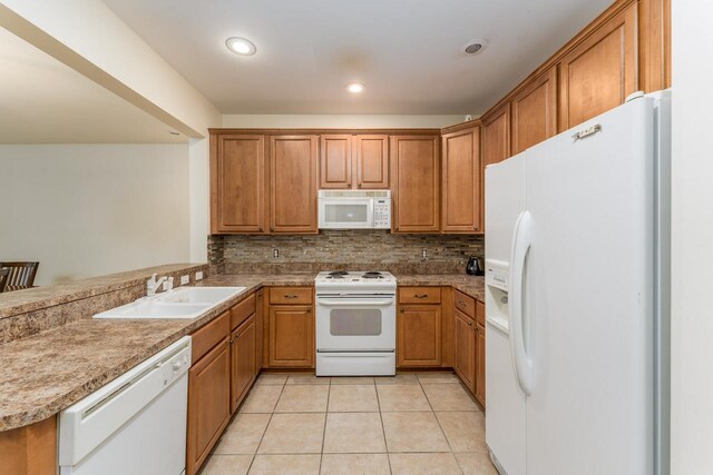 kitchen with kitchen peninsula, sink, tasteful backsplash, light tile patterned floors, and white appliances