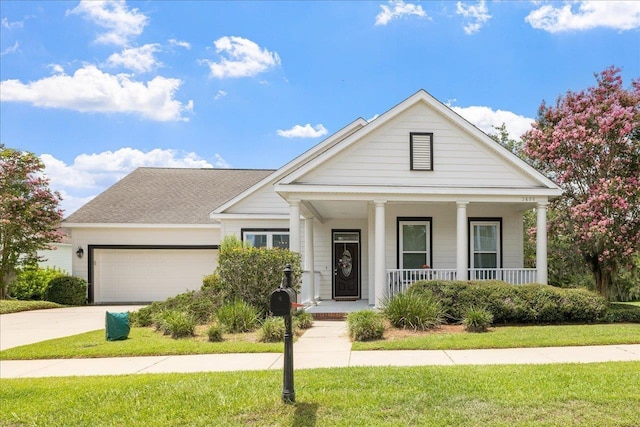view of front facade with a garage, a porch, driveway, and a front lawn
