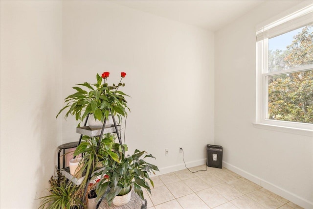 spare room with light tile patterned floors, baseboards, and a healthy amount of sunlight