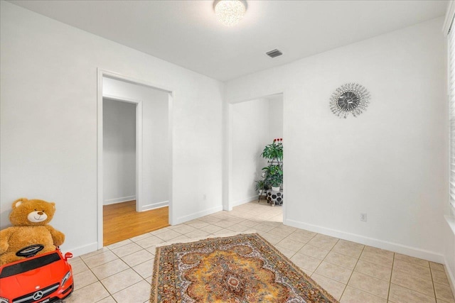 spare room with light tile patterned floors, baseboards, and visible vents