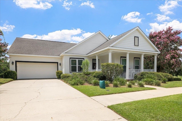 view of front of home with driveway, an attached garage, and covered porch