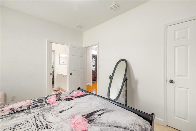 bedroom featuring visible vents, baseboards, and connected bathroom