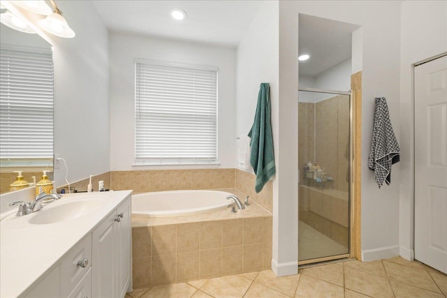 full bathroom with tile patterned floors, vanity, a garden tub, and a stall shower