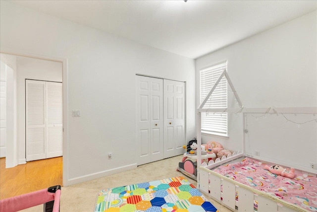 carpeted bedroom with a closet and baseboards