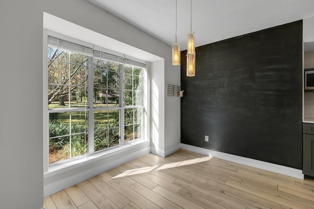 unfurnished dining area featuring light hardwood / wood-style floors