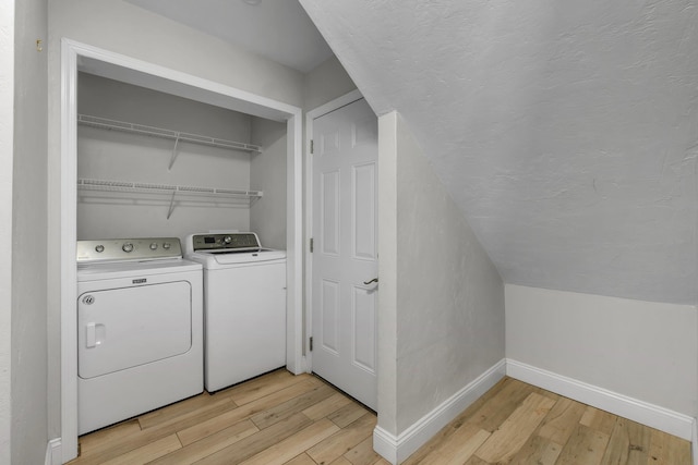 laundry room featuring washer and clothes dryer and light hardwood / wood-style flooring