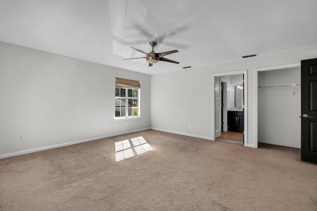 unfurnished bedroom with ceiling fan, carpet flooring, ensuite bath, and a closet