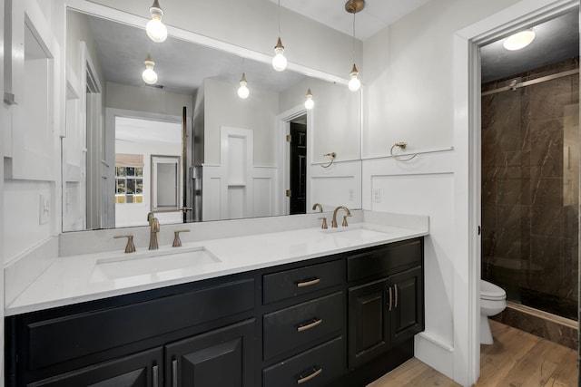 bathroom with toilet, wood-type flooring, vanity, and walk in shower