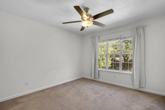 carpeted spare room featuring ceiling fan