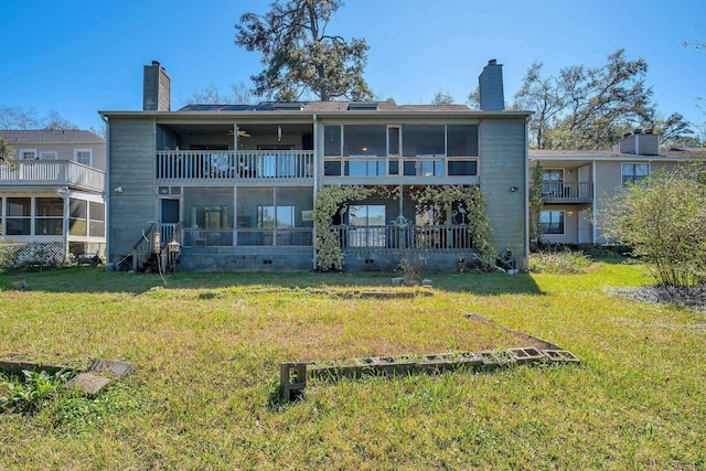 rear view of house with a yard and a balcony