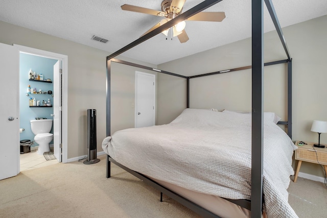 bedroom featuring light colored carpet, ceiling fan, a textured ceiling, and connected bathroom