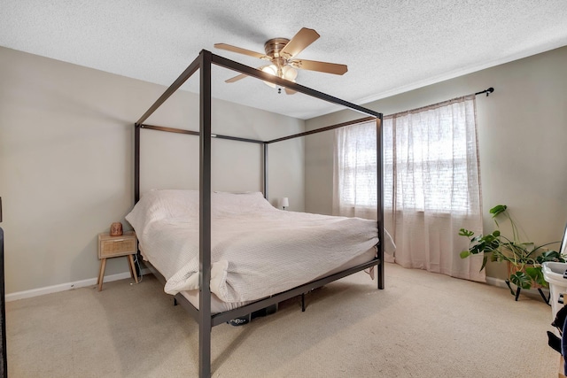 bedroom featuring a textured ceiling, light carpet, and ceiling fan