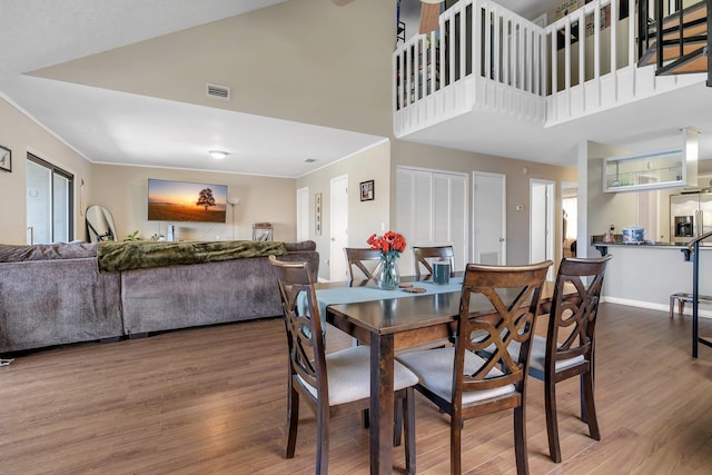 dining area featuring a high ceiling and dark hardwood / wood-style floors