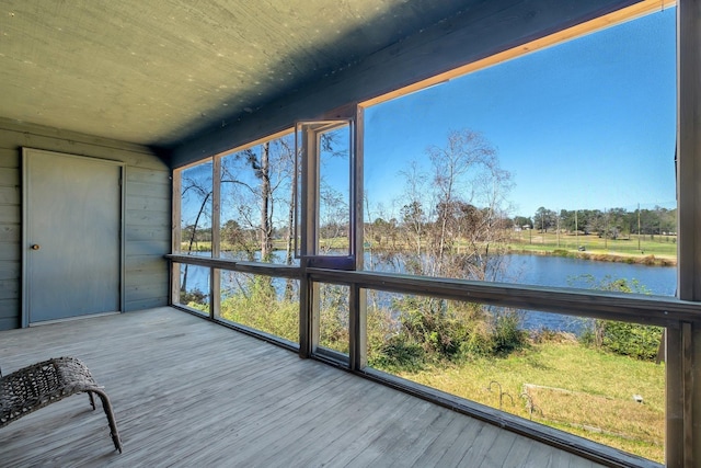 unfurnished sunroom featuring a water view