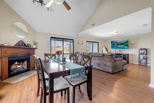 dining room featuring ceiling fan, high vaulted ceiling, and light hardwood / wood-style floors