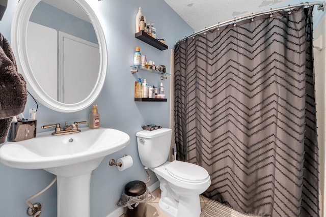 bathroom featuring a textured ceiling, curtained shower, and toilet