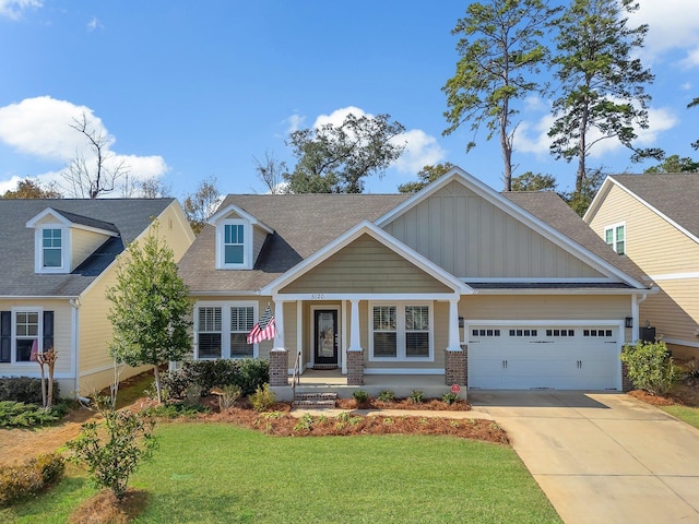 craftsman inspired home with a garage, covered porch, and a front lawn