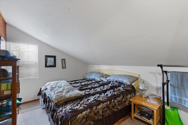 bedroom featuring lofted ceiling, light carpet, and a textured ceiling