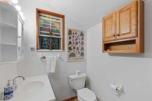 bathroom featuring vanity, vaulted ceiling, and toilet