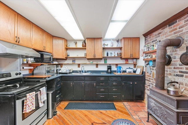 kitchen with sink, electric range, light hardwood / wood-style floors, and brick wall