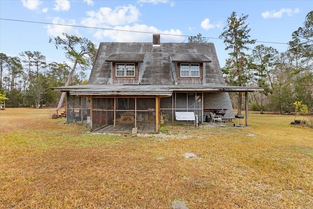 view of front of home with a sunroom and a front yard