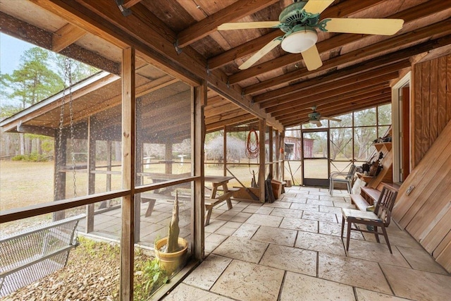 unfurnished sunroom featuring ceiling fan