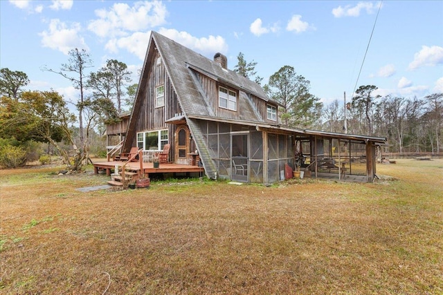 back of house featuring a wooden deck, a sunroom, and a yard