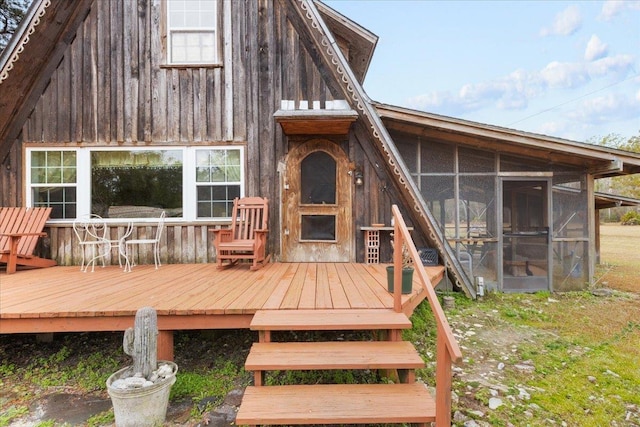 back of property featuring a wooden deck and a sunroom