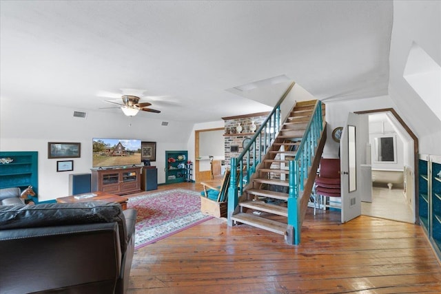 living room featuring hardwood / wood-style flooring, ceiling fan, and vaulted ceiling