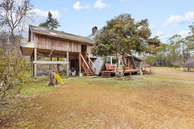 back of house with a lawn and a deck