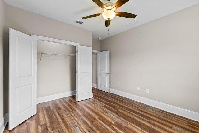 unfurnished bedroom with ceiling fan, a closet, and dark hardwood / wood-style floors