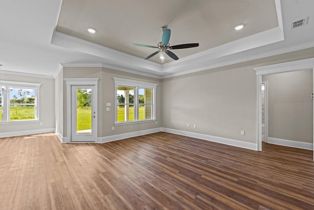 empty room featuring a tray ceiling, ceiling fan, and hardwood / wood-style flooring