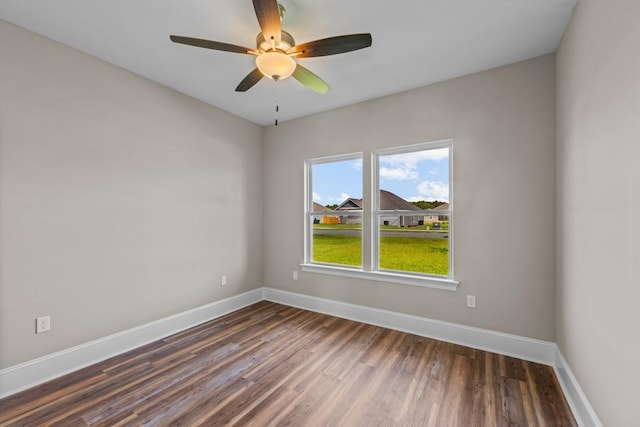 empty room with ceiling fan and dark hardwood / wood-style flooring