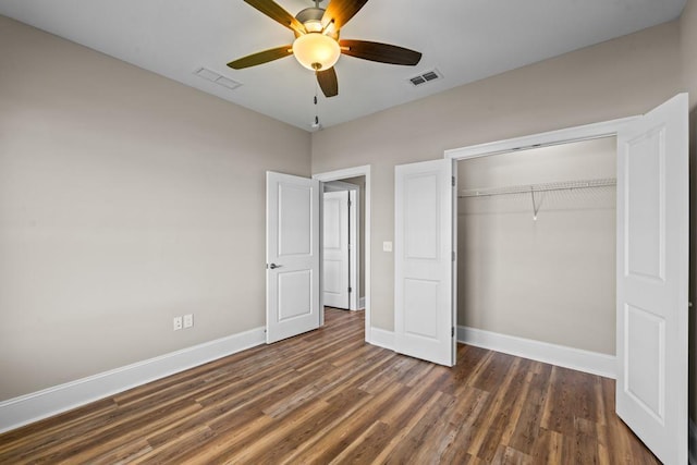 unfurnished bedroom featuring ceiling fan, dark hardwood / wood-style floors, and a closet