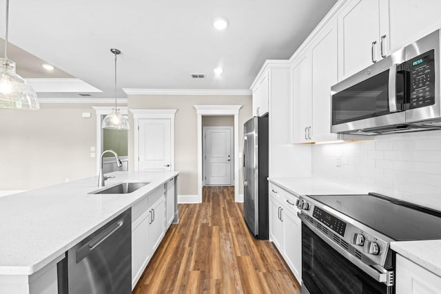 kitchen featuring ornamental molding, stainless steel appliances, sink, decorative light fixtures, and white cabinets