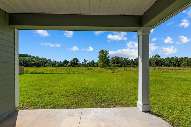 view of yard with a rural view and a patio area