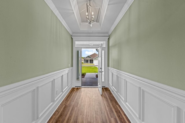 doorway with dark wood-type flooring, crown molding, and a chandelier